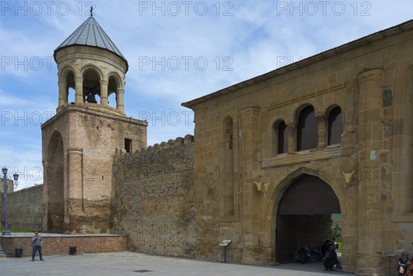 A historic bell tower and fortress walls under cloudy sky, Svetitskhoveli Cathedral, Svetitskhoveli, UNESCO World Heritage Site, Mtskheta, Mtskheta, Mtskheta-Mtianeti Region, Georgia