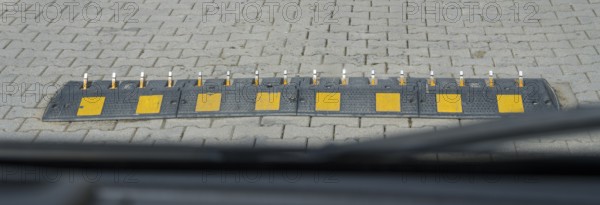 Ground obstruction with yellow markings on a paved road, one-way speed problems with spikes on the road, steel road spikes, destroys tires if you run over them from the wrong side, Mtskheta-Mtianeti region, Georgia