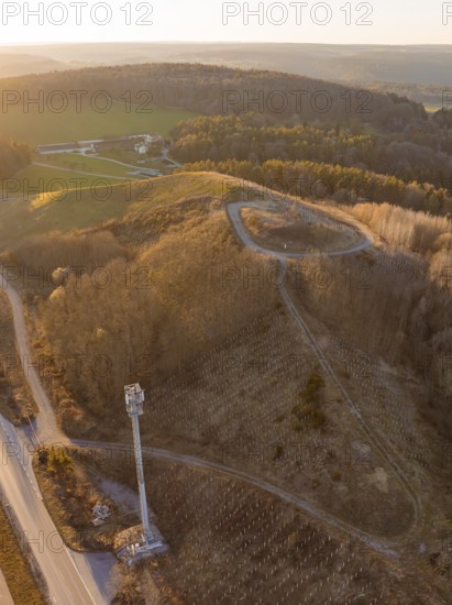 Wooded hilly landscape in the evening light with a road and wide views, future PV construction on old deposit, Lindenrain industrial park, Calw, Germany