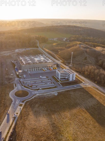 Industrial plant next to hilly landscape at sunset, future PV building on old deposit, Lindenrain industrial park, Calw, Germany