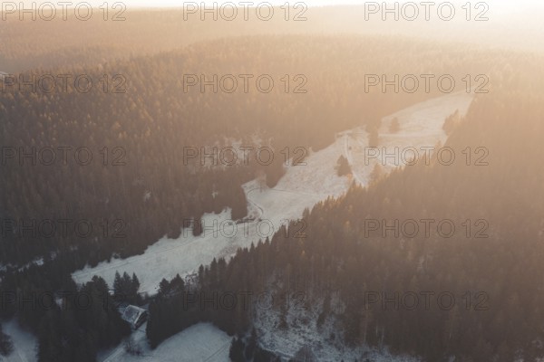 Snowy mountain landscape at sunset surrounded by thick forests, Enzklösterle, Calw district, Germany
