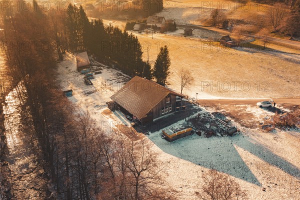 Evening winter landscape with a building surrounded by snow-covered fields and trees, Enzklösterle, Calw district, Germany