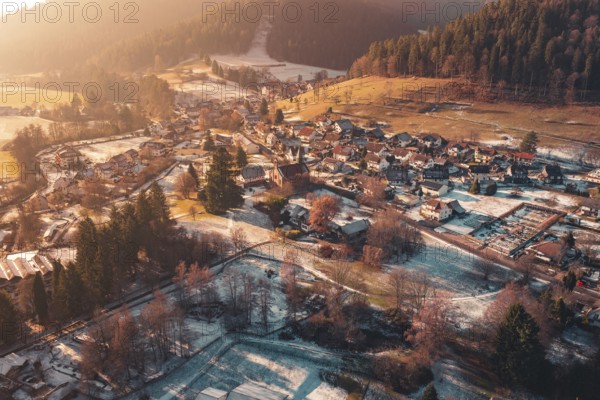 Expansive view of a village with snow-covered roofs surrounded by hills and forests, Enzklösterle, Calw district, Germany