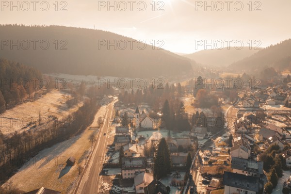 A snowy village with a church, surrounded by thick forests and bright skies, Enzklösterle, Calw district, Germany