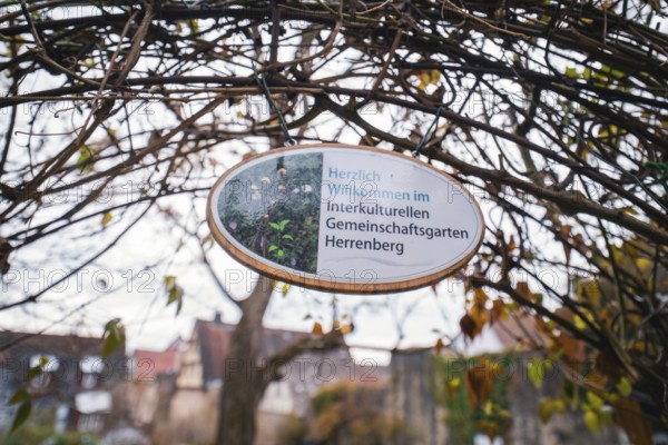 Wooden sign with welcome text for the intercultural community garden surrounded by branches, Herrenberg, Böblingen district, Germany