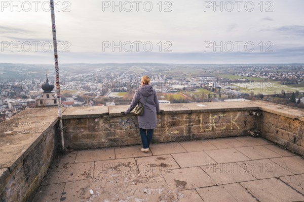 Woman standing on a viewing platform and enjoying the wide view over the city, Herrenberg, Böblingen district, Germany