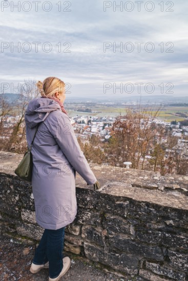 Woman in a coat looking out over a quiet winter landscape with a wide view, Herrenberg, Böblingen district, Germany