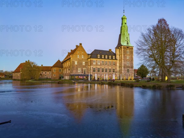 View in winter over partially frozen moat at castle converted into a Renaissance castle today Raesfeld moated castle from the 14th to 17th century with main castle in front, part of Vorburg in the background on the left, Freiheit Raesfeld, Hohe Mark nature park Park, Münsterland, North Rhine-Westphalia, Germany