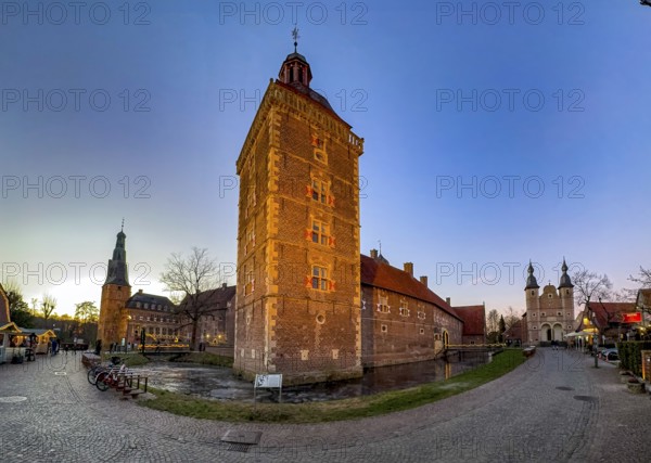 Panoramic photo in winter on winter evening from left on the edge of the picture Raesfeld Castle in the middle Observatory Tower stands in Wassergraben right next to part of Vorburg, right on the edge of the picture St. Sebastian Castle, Raesfeld Water Castle, Freiheit Raesfeld, nature park Park Hohe Mark, Münsterland, North Rhine-Westphalia, Germany