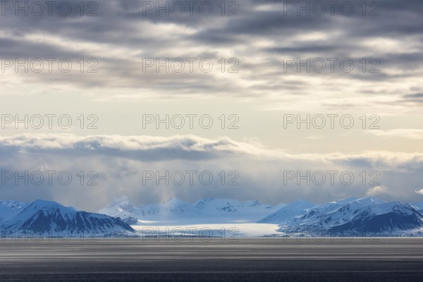 Glaciers between snow-capped mountains at sea, clouds, Longyearbyen, Spitsbergen, Svalbard