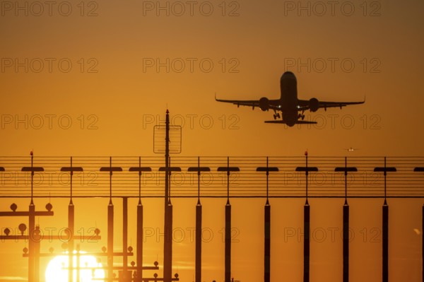 Runway lighting, approach aids, at Düsseldorf International airport, sunset, aviator taking off, in the background aircraft landing on the main runway south, 05R/23L, North Rhine-Westphalia, Germany