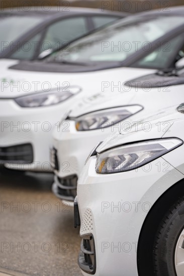 Close-up of parked white electric cars, focus on headlights, ID3, Deer e-car sharing, Germany