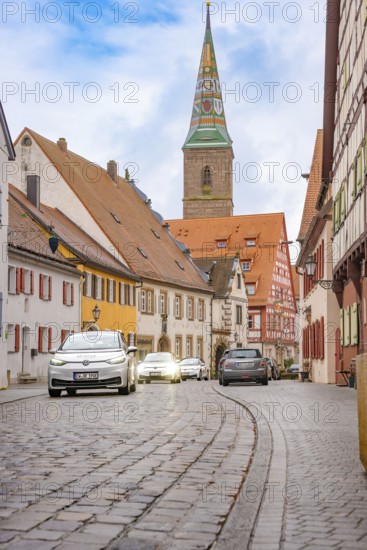 Historic old town with cobblestones and colorful houses, a church tower in the background, ID3, deer e-car sharing, Germany