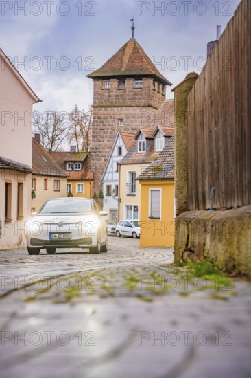 Scene in Altstadtgasse with cobblestones and a fortified tower, ID3, Deer E-Carsharing, Germany