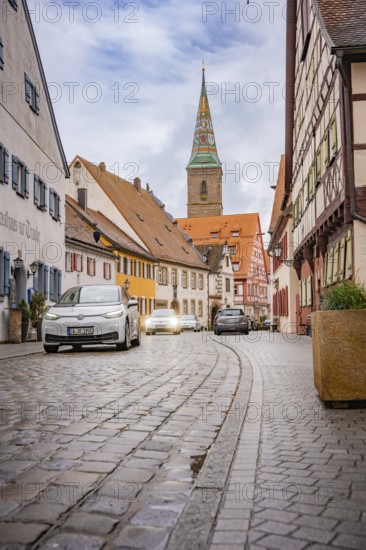 Narrow paved alley in historic old town with church tower, ID3, deer e-car sharing, Germany