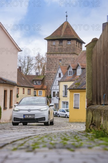 Picturesque alley in the old town with cobblestones and defensive towers, ID3, deer e-car sharing, Germany