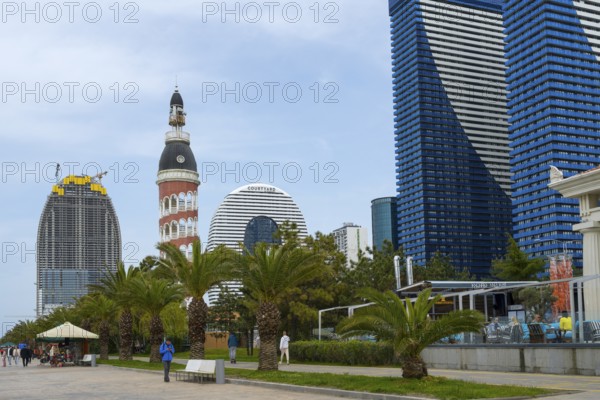 A mix of modern skyscrapers and a round tower offers a contrasting city view under cloudy sky, Batumi, Black Sea, Ajara region, Adjara, Autonomous Republic, Georgia
