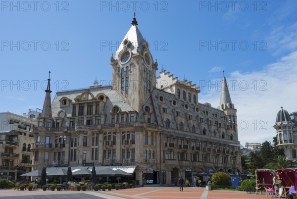 Large building with towers and roof gables in a sunny public square, Europe Square, Batumi, Black Sea, Ajara region, Adjara, Autonomous Republic, Georgia