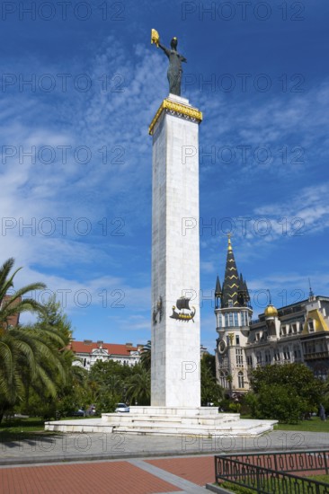 Tall column with statue in a square next to a magnificent building and tower, statue of Medea, Europe Square, Batumi, Black Sea, Ajara region, Adjara, autonomous republic, Georgia