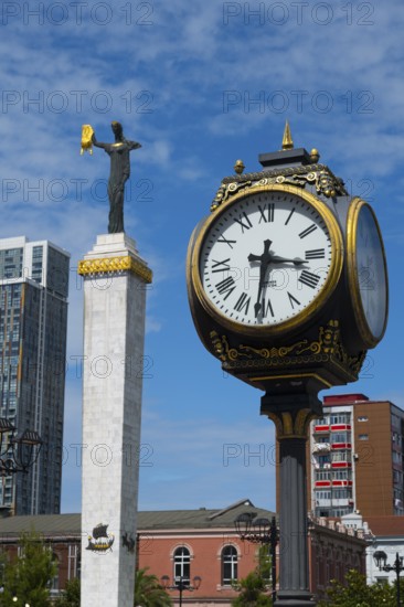 Large clock and statue in front of modern buildings under bright blue sky, clock and statue of Medea, Europe Square, Batumi, Black Sea, Ajara region, Adjara, Autonomous Republic, Georgia