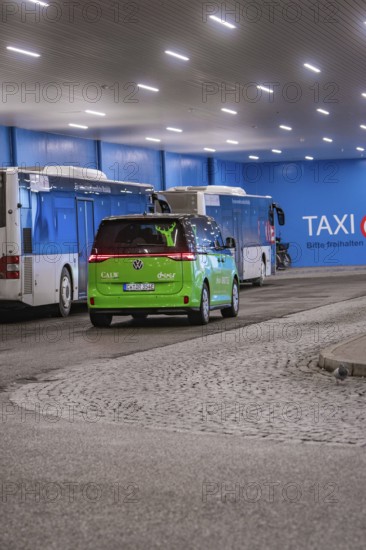 Interior view of a bus stop with green shuttle and buses, urban atmosphere, Deer E-Mobility Shuttle Service, Calw, Germany