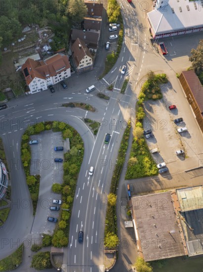 Drone view of a busy road junction with adjacent buildings and vegetation, Deer E-Mobility Shuttle Service, Calw, Germany