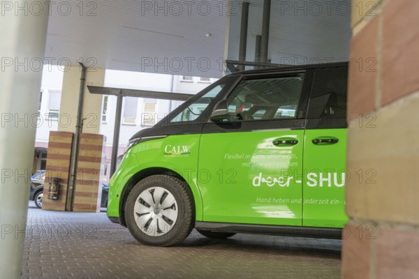 Green car in a parking lot, modern and stylish under canopy, Deer E-Mobility Shuttle Service, Calw, Germany