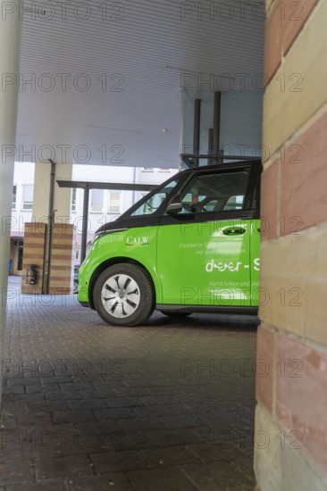 Green car in a covered area of a modern city, Deer E-Mobility Shuttle Service, Calw, Germany