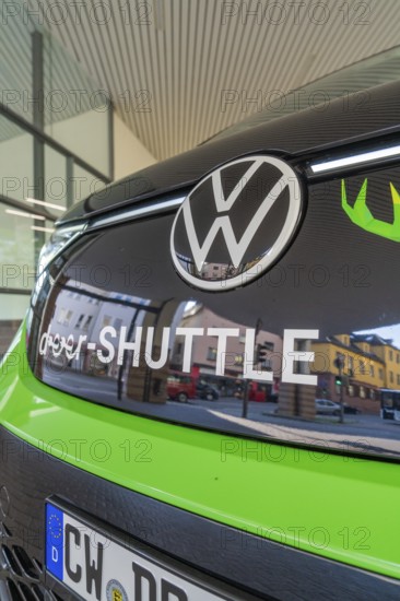 Front view of a green VW with sign in an urban environment, Deer E-Mobility Shuttle Service, Calw, Germany