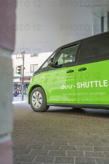 Green shuttle is under roof in urban area, Deer E-Mobility Shuttle Service, Calw, Germany