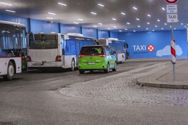 Bus station with green shuttle and taxi signs, urban scene at night, Deer E-Mobility Shuttle Service, Calw, Germany