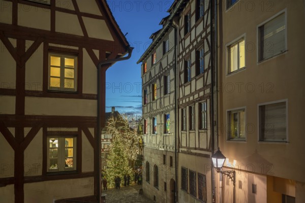Historic half-timbered houses with a view of the Christmassy decorated Tiergärtnertorplatz in the evening lighting, Ölberg, Nuremberg, Middle Franconia, Bavaria, Germany