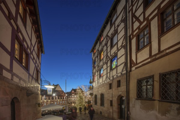 Historic half-timbered houses with a view of the Christmassy decorated Tiergärtnertorplatz in the evening lighting, on the right the Pilatus House with advent calendar, Ölberg, Nuremberg, Middle Franconia, Bavaria, Germany