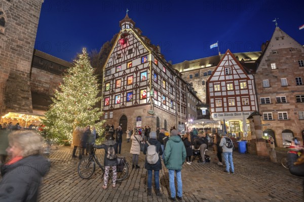 Christmassy illuminated square with the historic Pilate House with advent calendar, in the evening lighting, the Kaiserburg in the back, Beim Tiergärtnertor, Nuremberg, Middle Franconia, Bavaria, Germany