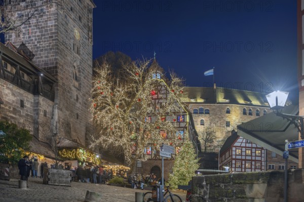 Christmassy illuminated square with the historic Pilate House with advent calendar, in the evening lighting, the Kaiserburg in the back, Beim Tiergärtnertor, Nuremberg, Middle Franconia, Bavaria, Germany