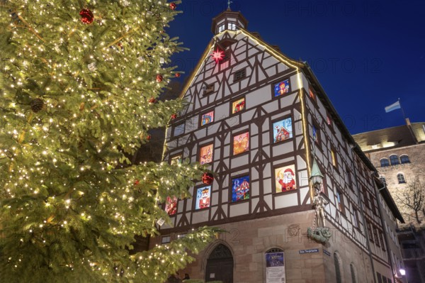 The historic Pilate House with advent calendar and Christmas tree in the evenings, Tiergärtnertorplatz, Nuremberg, Middle Franconia, Bavaria, Germany