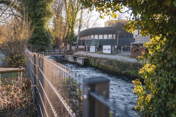 River along a building surrounded by trees and a fence, Stadtgarten Pforzheim, Germany