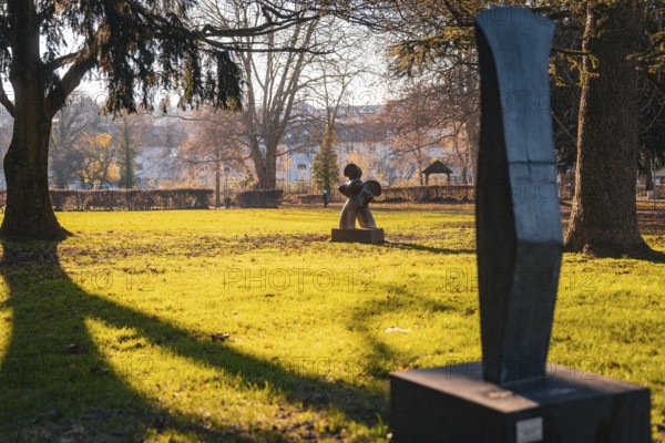 Sculptures on a sunny green area in the park in autumn, Stadtgarten Pforzheim, Germany