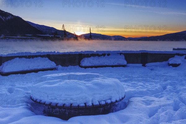 Snowy harbor at sunset, overlooking the water, Mo i Rana, Norway