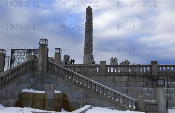 Monolith and statues on snowy stairs, cold winter atmosphere, Vigeland sculpture park Oslo Norway