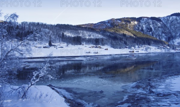 Snowy landscape with hills and river in winter, Norway