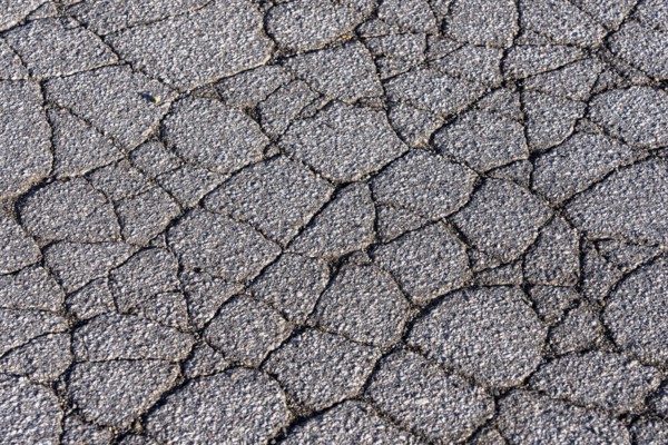 Asphalt surface, floor, with many small cracks, roadway, parking lot