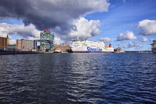 Kiel Fjord, Stena Germanica ferry, Stena Line GmbH, ferry, port house, high-rise building, modern architecture, general development, port, wharf, portal crane, seaport Kiel GmbH and Co. KG, water surface with small waves, blue sky, cumulus clouds, stratocumulus clouds, white and dark clouds, Kiel, state capital, district-free city, Schleswig-Holstein, Germany