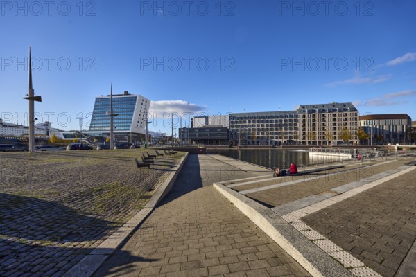 Boat port, water area, general architecture, commercial buildings, modern buildings, Schwedenkai ferry terminal, casino, hotel, Accor Group, Adagio Access, ibis Styles, lantern, seating steps, benches, abstract reflections on the water surface, seated people as a secondary motif, side light, blue sky, cumulus clouds, Holstenbrücke and Kaistraße streets, Kiel, state capital, district-free city, Schleswig-Holstein, Germany