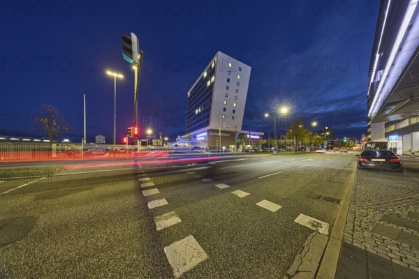 Schwedenkai ferry terminal, Stena Line GmbH, commercial building, modern architecture, lantern, parking strip with vehicles, pedestrian crossing with traffic lights, traffic lights, central island, lanes, trees, evening blue hour, deep blue evening sky, cumulus clouds, quay road, Kiel, state capital, district-free city, Schleswig-Holstein, Germany