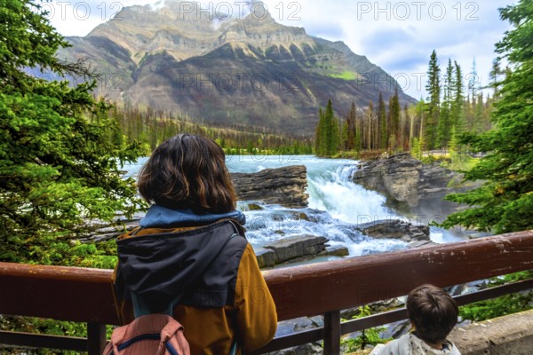 Tourists are enjoying the breathtaking view of athabasca falls, a powerful waterfall located in jasper national park, a unesco world heritage site in the canadian rockies, alberta, canada