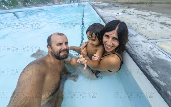 Happy family taking a selfie while enjoying a relaxing bath in the miette hot springs, located in the stunning jasper national park, a renowned destination in the canadian rockies
