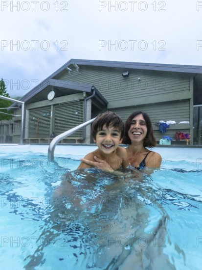 Mother and son are smiling and having fun while bathing in miette hot springs, located in the stunning jasper national park, a renowned destination in the canadian rockies