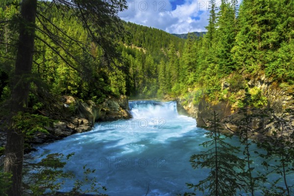 Majestic overlander falls cascading into the vibrant turquoise waters of the fraser river, surrounded by lush forests and the dramatic landscapes of mount robson provincial park