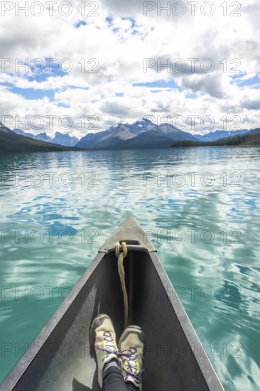 Canoeing on maligne lake in jasper national park, alberta, showcases breathtaking views of the canadian rockies, with turquoise waters reflecting a cloudy sky